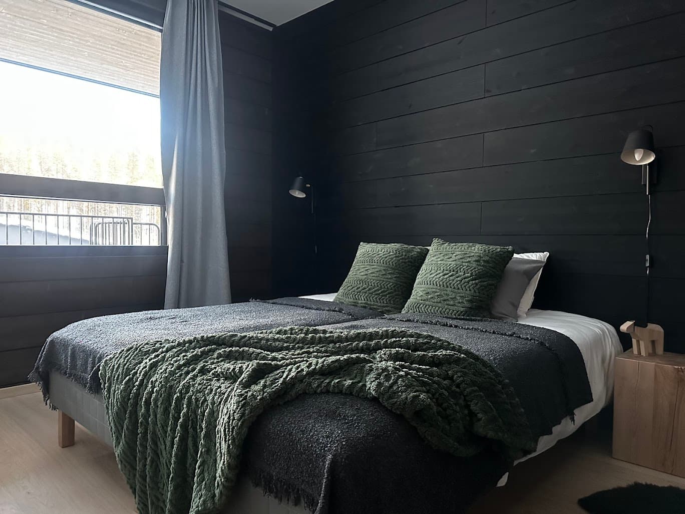 A bedroom framed in pine with warm winter light
